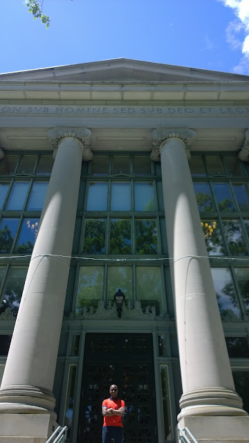 Alexander Nwala standing at the main entrance of Langdell Hall