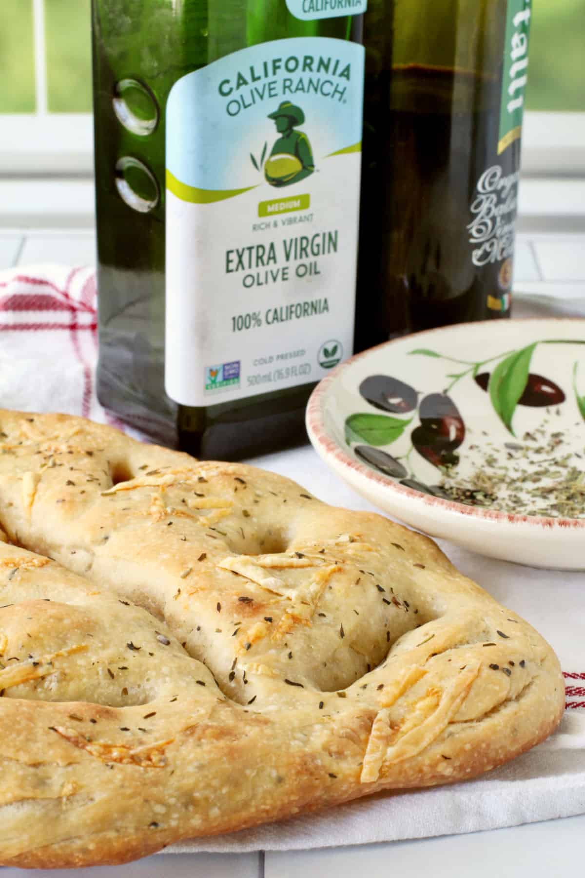 Fougasse Bread with Herbs de Provence and Gruyère Cheese with an olive oil bottle.