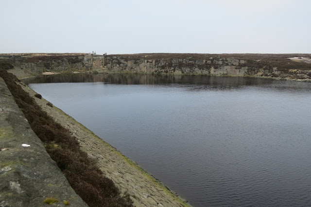 The northern end of Warland Reservoir, edged by sheer rock faces.