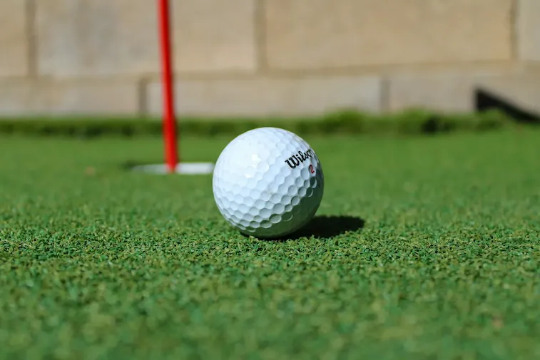A golf ball sitting on top of a green field