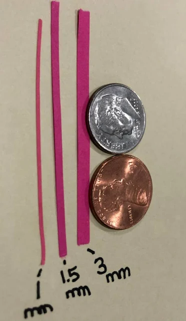 examples of 1mm, 1.5mm, and 3mm fuchsia quilliing strips shown next to dime and penny for scale