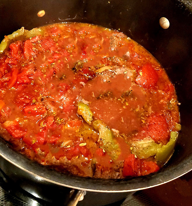 a pot of tomatoes and and peppers making homemade ketchup