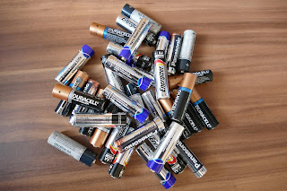 a variety of batteries in a pile on a table