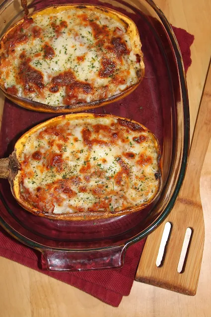 Baking dish with two halves of pepperoni pizza stuffed spaghetti squash.