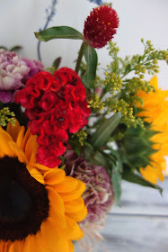 Huckleberry, Salvia, Solidago, Charmelia, Gomphrena, Celosia, Dahlias, Carnations, and Sunflowers.