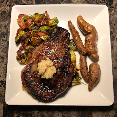 Rare grilled bison ribeye, grilled leeks, oven roasted fingerling sweet potatoes and maple bacon roasted Brussels sprouts