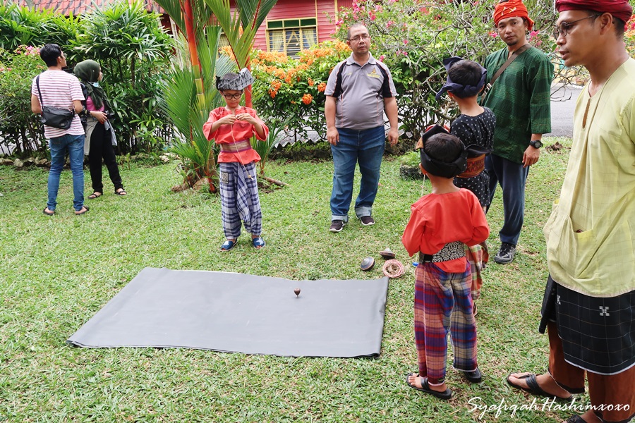 kanak-kanak sedang demonstrasi permainan Gasing