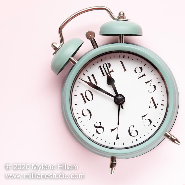 Retro green alarm clock on pastel pink background