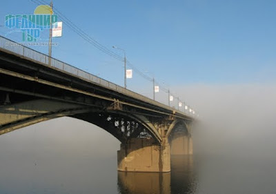 Арочный мост через реку в тумане.