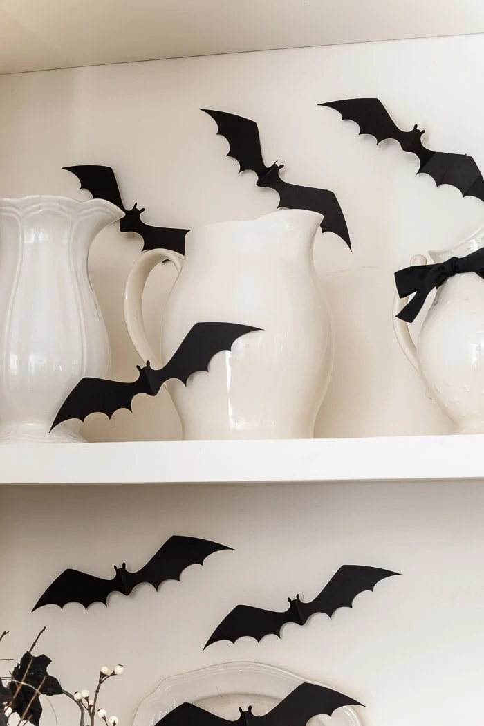 black paper bats on bookshelves