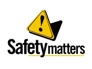 triangle shaped yellow sign with a black exclamation point and words under the sign written in black that say safety first
