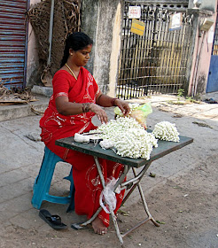 woman on street selling flower strings to decorate hair