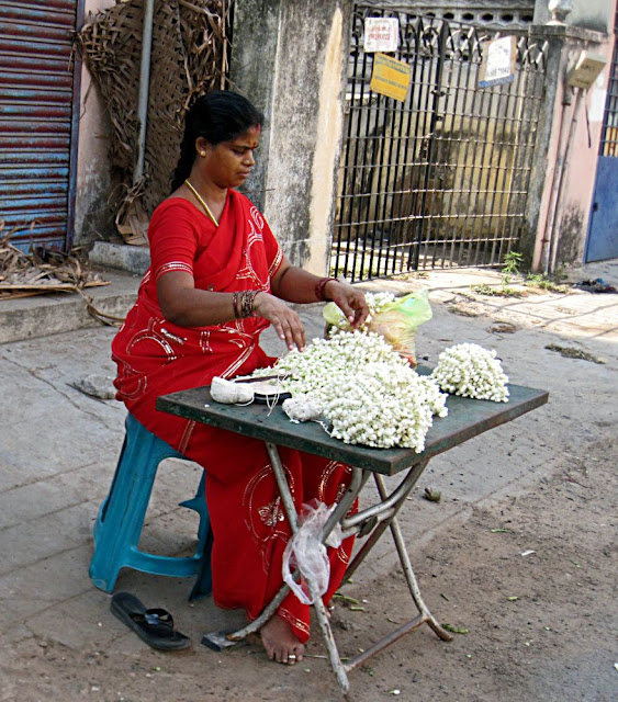 woman on street selling flower strings to decorate hair