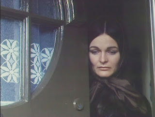 Still from Bleak Moments - woman opening front door of house