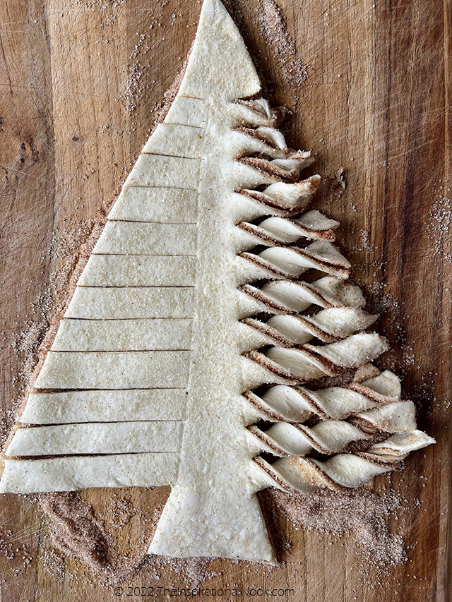 Twisting puff pastry to make Christmas tree branches