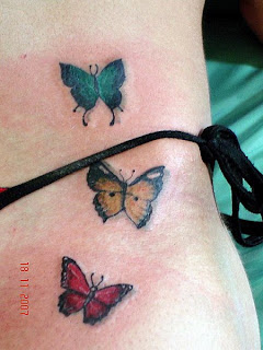 Três borboletas tatuadas na região do quadril