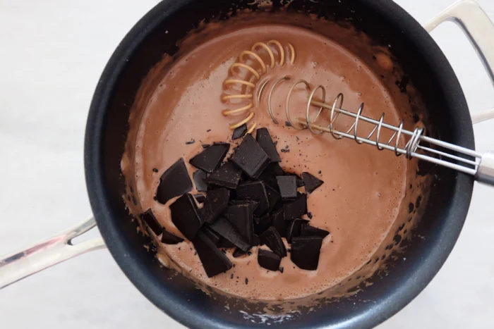 adding chopped chocolate to custard