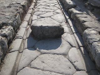 The cartwheel ruts carved into the ancient stone road of Pompeii.