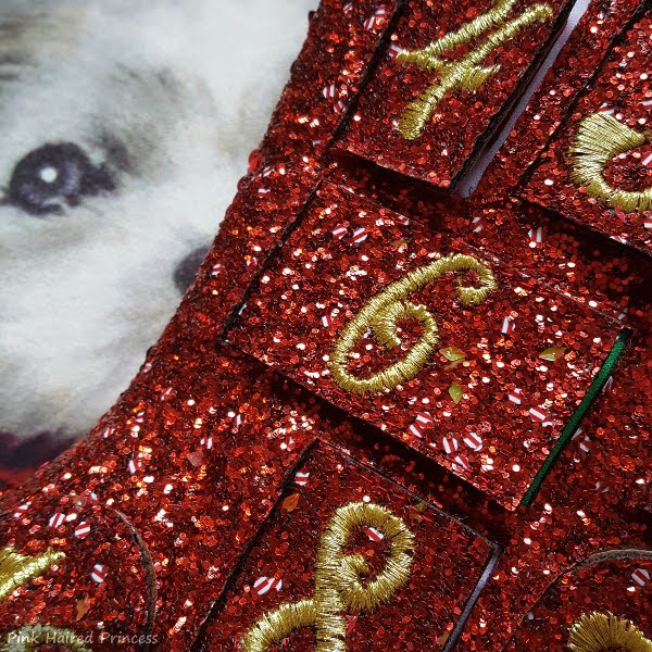 close up of red glitter boots with striped discs and green gems