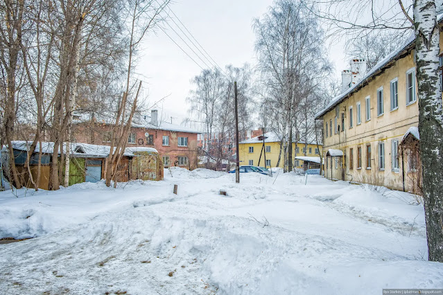 Заснеженный пустырь среди жилых зданий