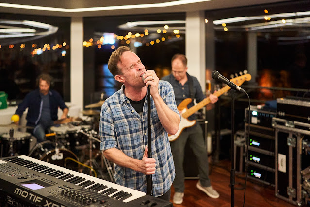 picture of man singing behind keyboard