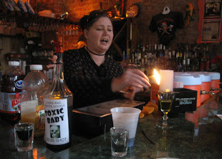 Bartender lighting up the sugarcube of an absinth drink, New Orleans