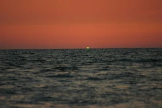 green flash at sunset as seen across the open sea