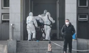 A equipe médica leva um paciente para um hospital em Wuhan, onde pacientes infectados com o coronavírus estão sendo tratados. Fotografia: EPA