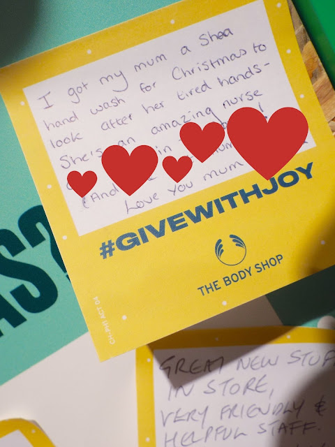 A close up shot of my little yellow "Give the Gift Of Joy" Post-It-Note, reading, I got my mum a shea hand wash to look after her tired hands - she's an amazing nurse. Love you mum x .
