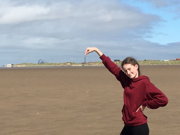 teen on beach, pointing to Blackpool Tower