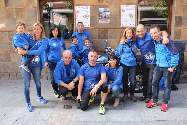 Integrantes del Centro Gallego y de la asociación La Cuadri del Hospi posan con la moto Harley Davidson donada por el música Fito