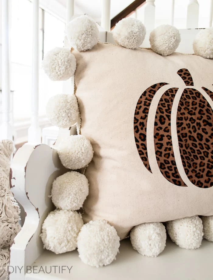 pillow with pom poms and cheetah print