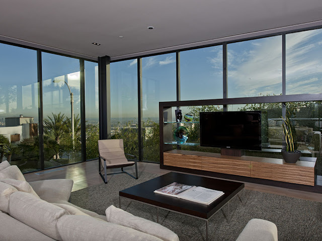 Photo of modern living room furniture by the windows with the city view
