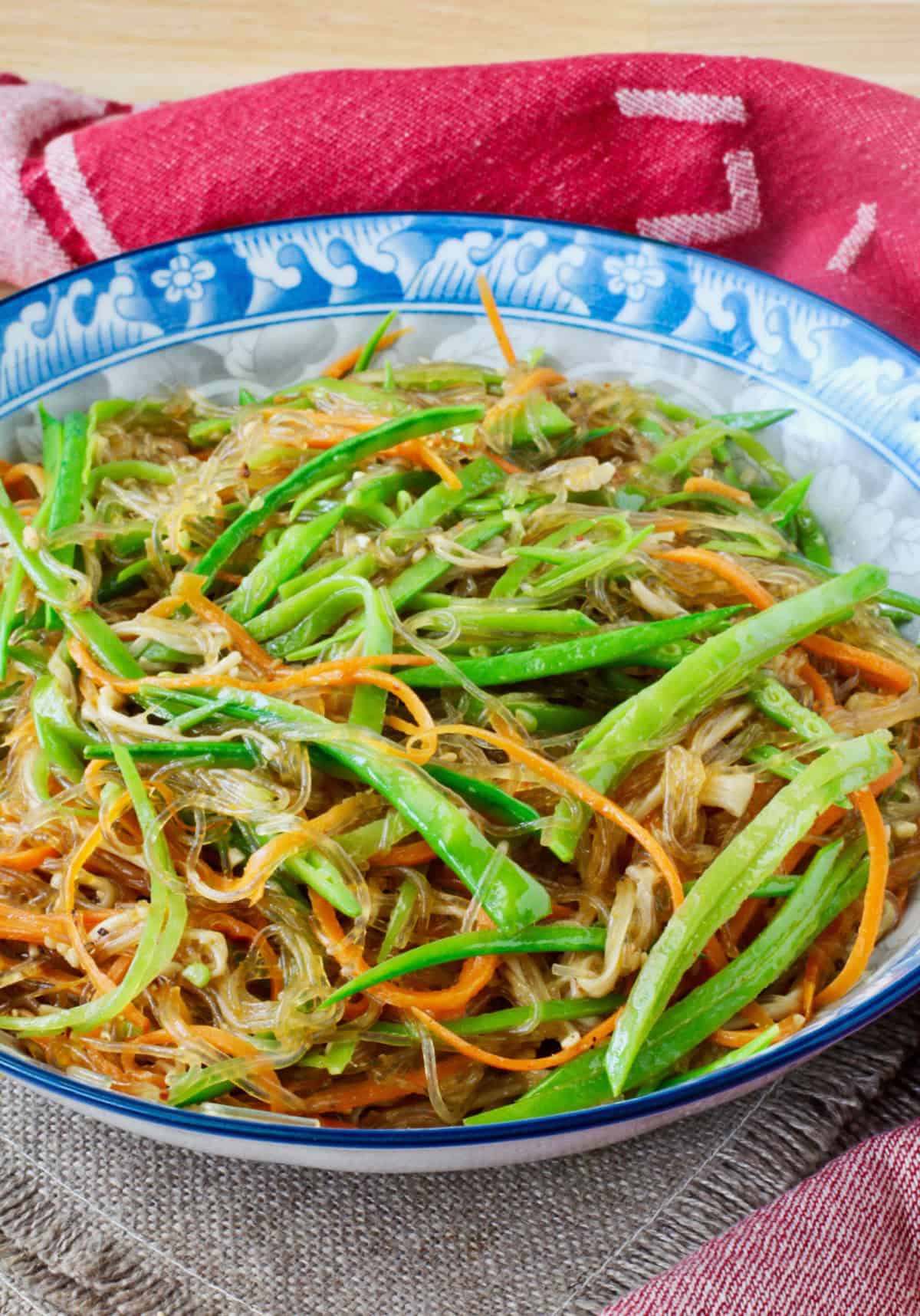 Stir-Fried Cellophane Noodles with Enoki Mushrooms in a blue patterned bowl.