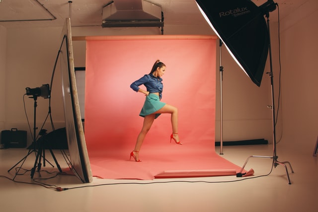 Photoshoot of a woman in front of a red background.