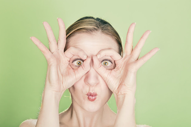 Funny woman using hands as mask, eyes