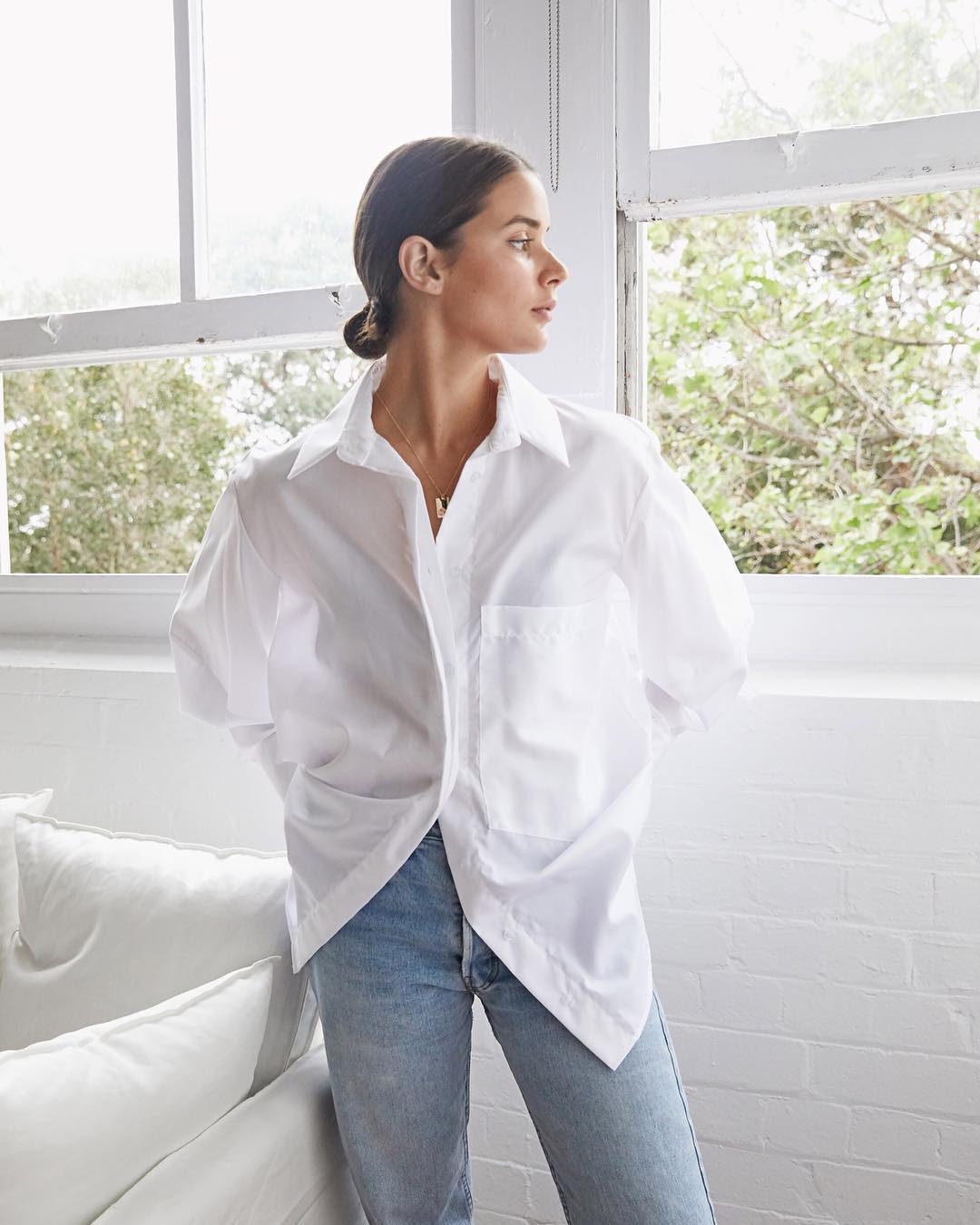 15 Crisp White Button-Down Shirts You Can Wear Year-Round — Sara Crampton of Harper & Harley with a low bun, white top, and jeans