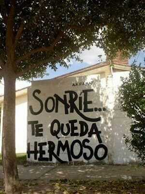 Graffiti con la frase "Sonríe, te queda hermoso"