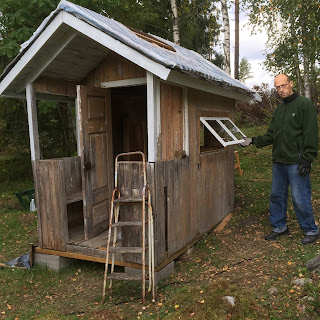 Kisokfönstret är avlångt med två rutor. Vid den omålade väggen står Hasse och håller ut fönstret där det hänger i sina gångjärn.