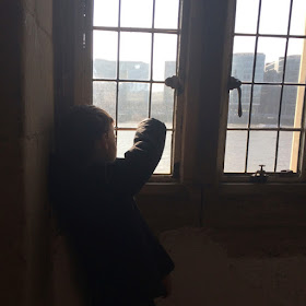 Boy looking out of window at city