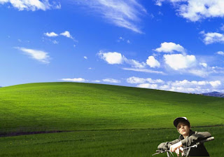 Justin Bieber free posters wallpapers riding his a bike and watching the fans in classic Bliss Landscape background