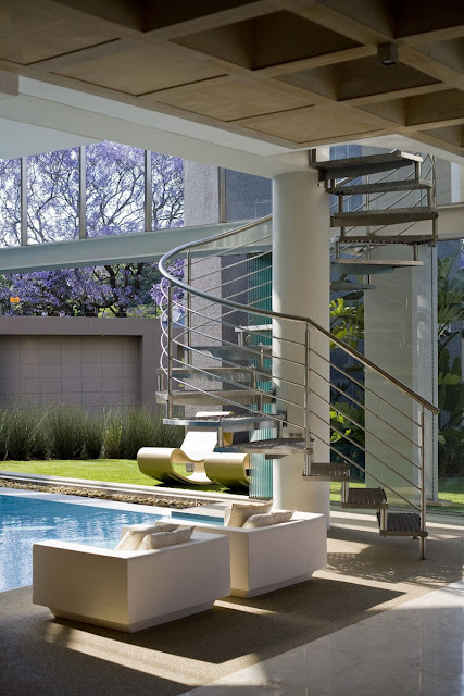 Photo of spiral staircase by the pool with two sofas in front