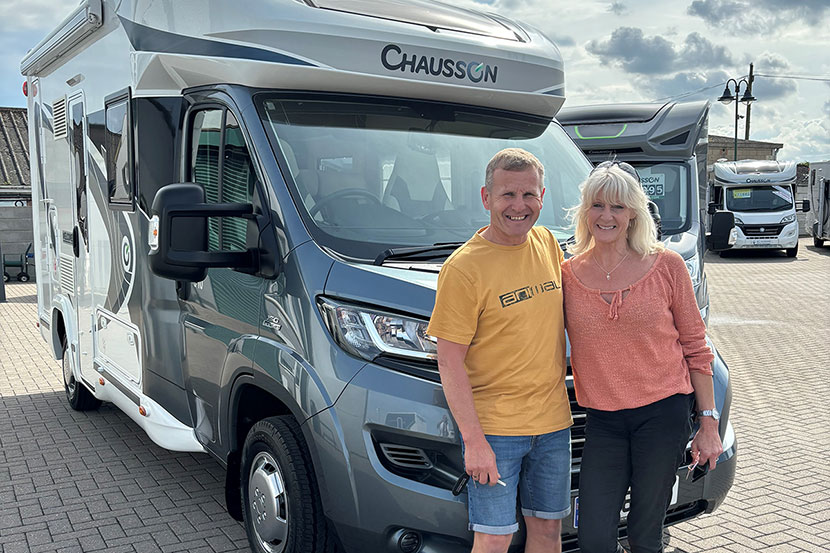 Couple standing next to new motorhome