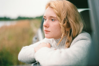 a picture shows a young woman gazing out of a car window