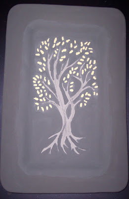 Tree design with gold leaves painted in glaze on ceramic platter.