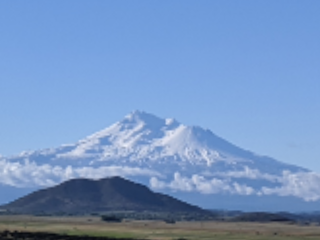 View of Mount Shasta against a bright blue sky.