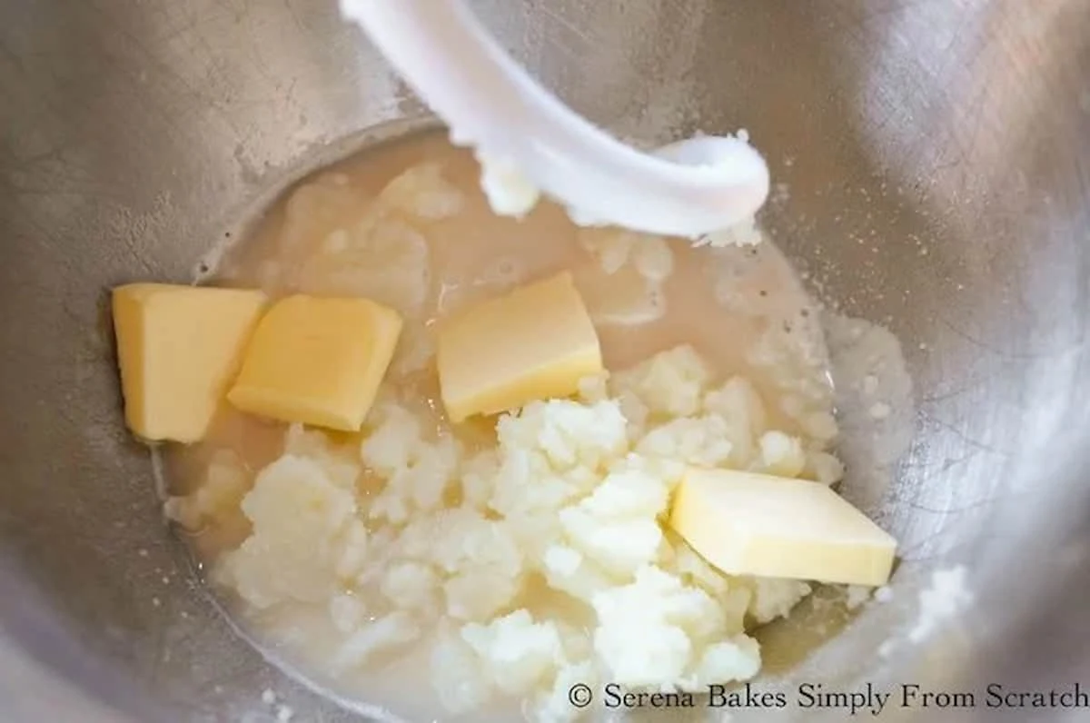 Yeast Mixture, Mashed Potatoes, Beaten Eggs, Butter and Honey in a stainless steel mixing bowl.
