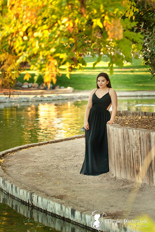 Professional photograph of an Atrisco high school senior on top at the UNM Duck Pond Albuquerque
