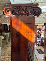 Slanting sunlight on the capitol of a wood column.