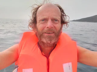 I with an orange survival jacket in the boat on the sea